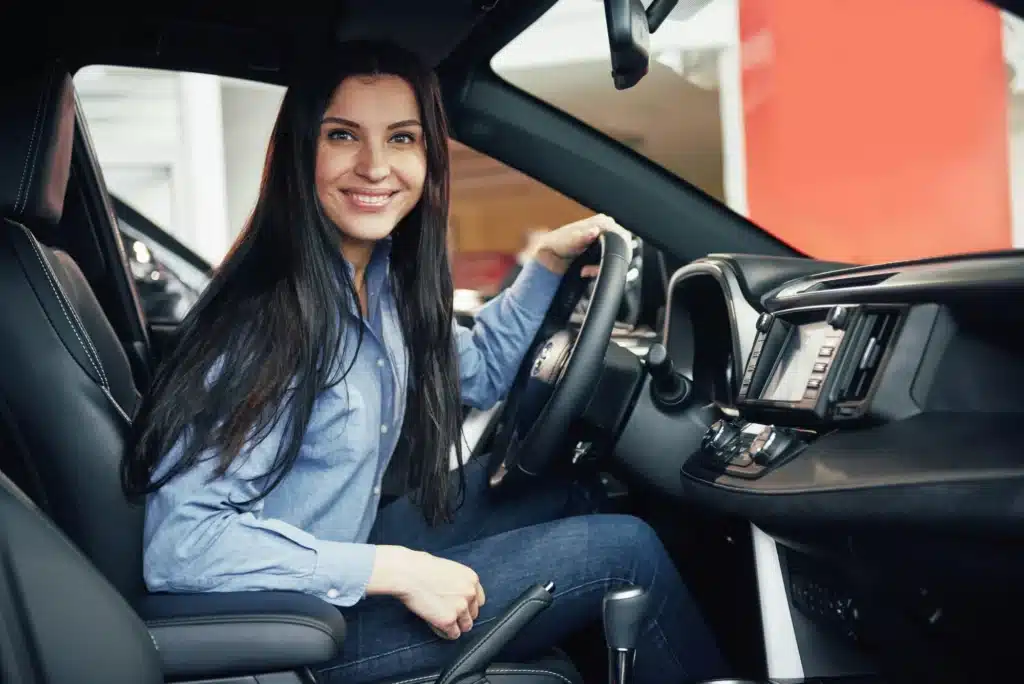 A person looks happy behind the driver's wheel of a car after fighting a traffic ticket and winning.