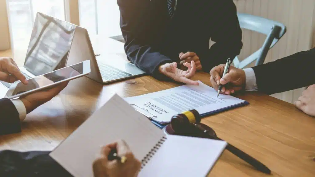 A person speaks with a group of lawyers before criminal court.