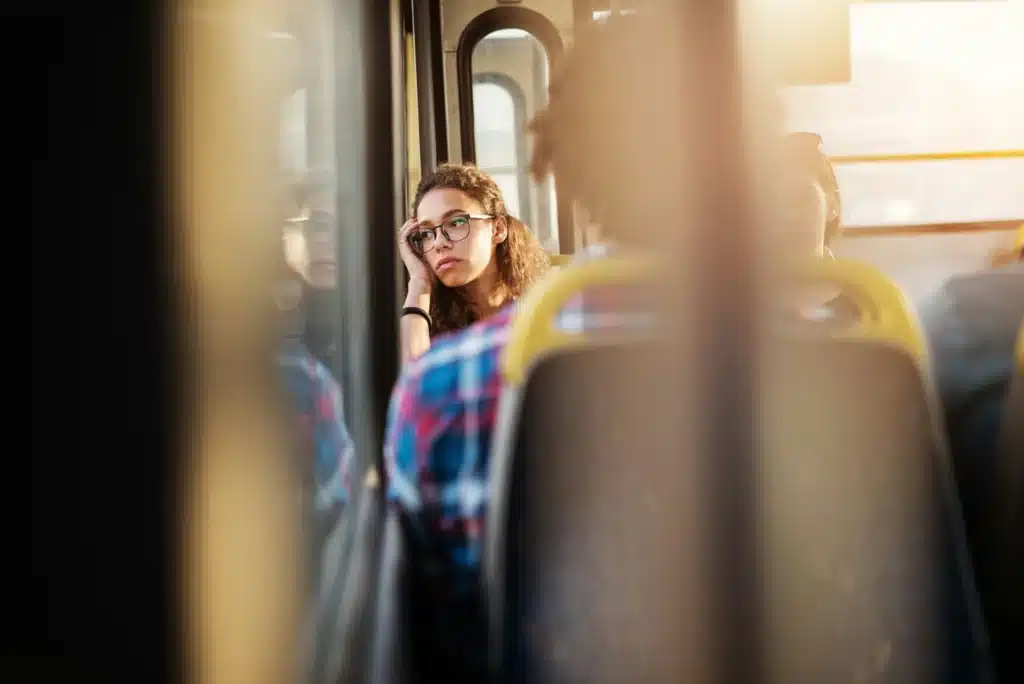 A person looks sad while riding the bus to work after getting too many demerit points.