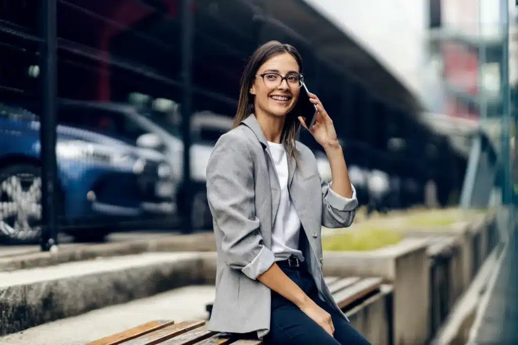 A person smiles while on the phone with a traffic ticket expert.