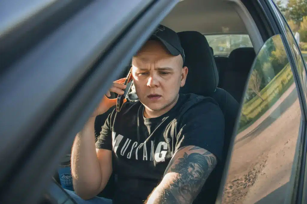 A person who just got a traffic ticket looks worried as they make a call.