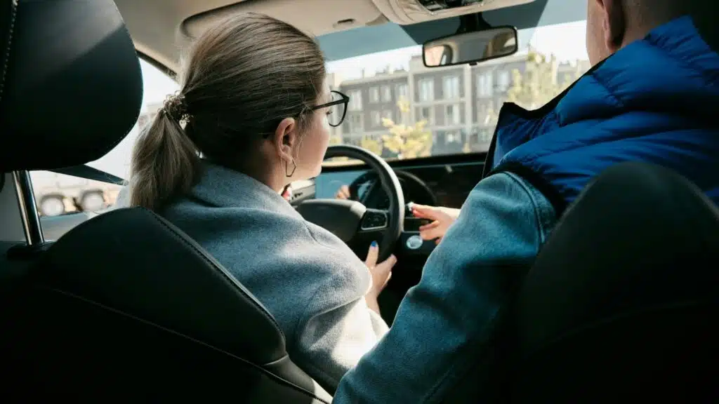 A driving instructor explains the rules of the road and importance of driving the speed limit to a new driver in Calgary