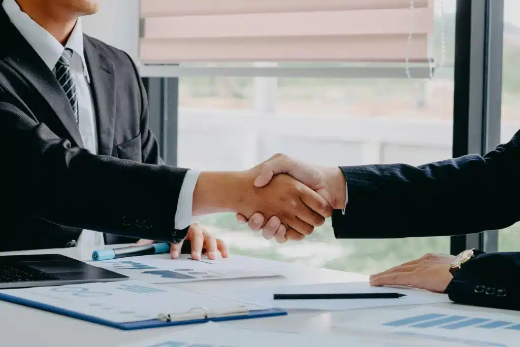 A person shakes hands with a traffic ticket expert after going over the details of their careless driving charge.